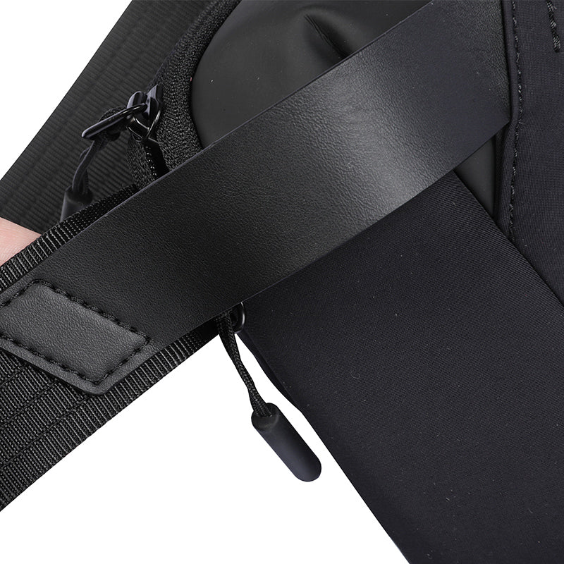 Close-up of Vivi travel bag by MarkRyden, highlighting black leather strap with stitching, durable fabric, and zipper pull.
