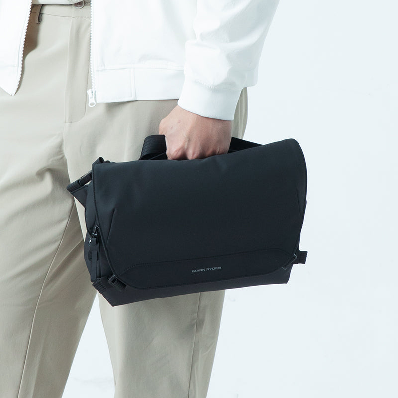 Person holding black Mark Ryden waterproof sling bag for urban gamers