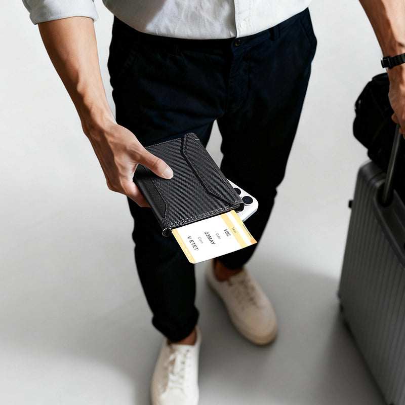 Black textured crossbody travel card wallet holding boarding pass, with suitcase in background for travel convenience.