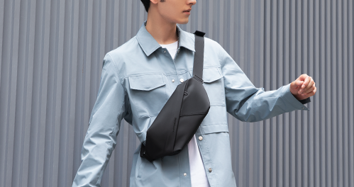 Man wearing black crossbody bag styled with light blue jacket - MarkRyden Global anti-theft travel accessory