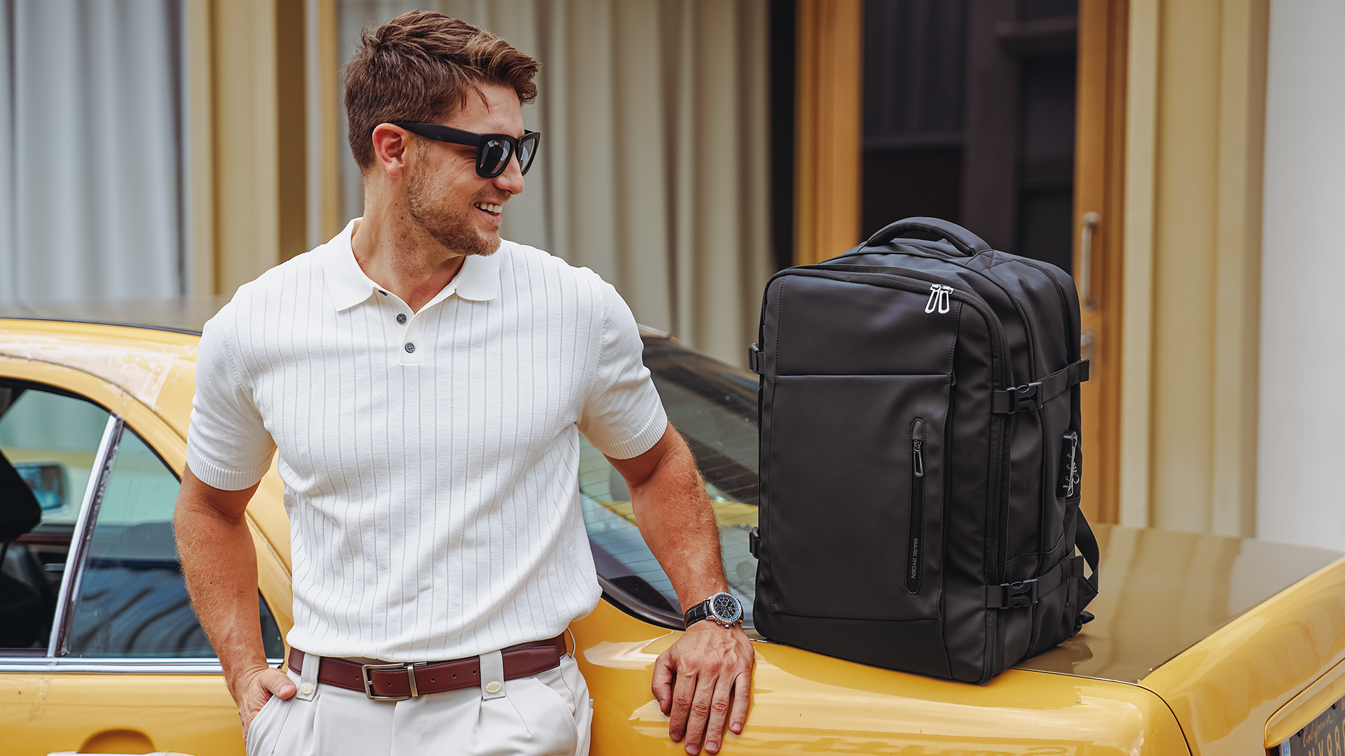 Mark Ryden black anti-theft backpack on yellow car - modern travel essential