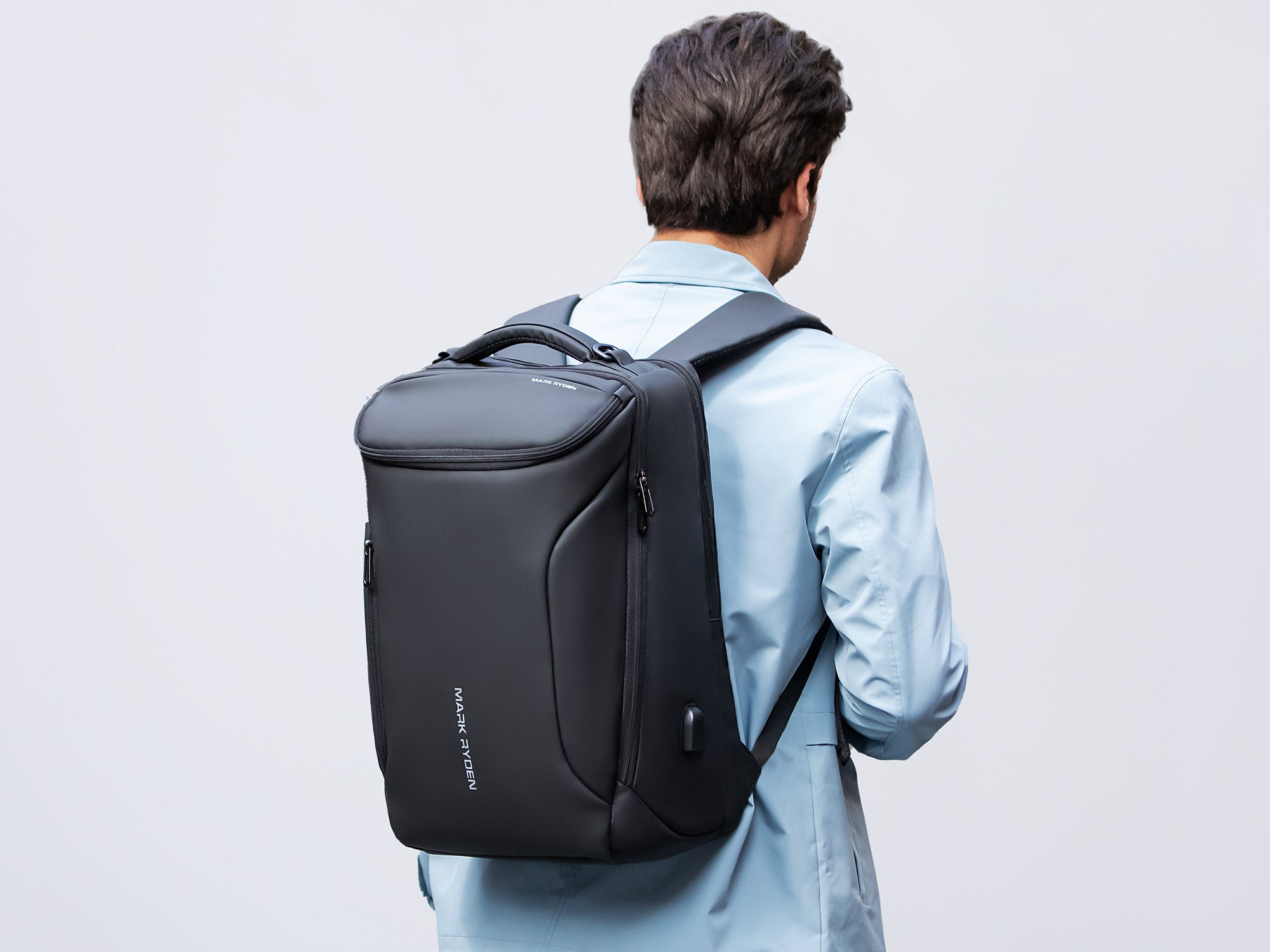 Mark Ryden black weatherproof anti-theft backpack worn by modern traveler