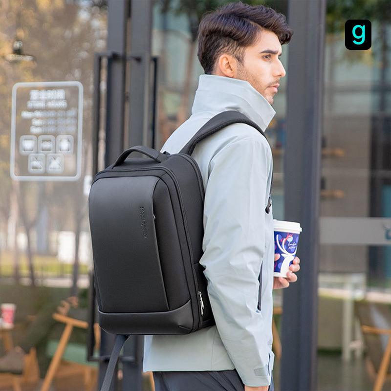 Black Multi-functional Travel Mate backpack with USB port, durable waterproof high-capacity design, worn by man holding coffee in urban setting