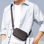 Black ribbed small crossbody purse with adjustable strap, worn by a person in a light blue shirt, ideal for travel comfort.