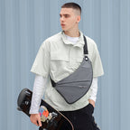 Gray anti-theft chest bag with black strap worn by modern urban traveler with skateboard