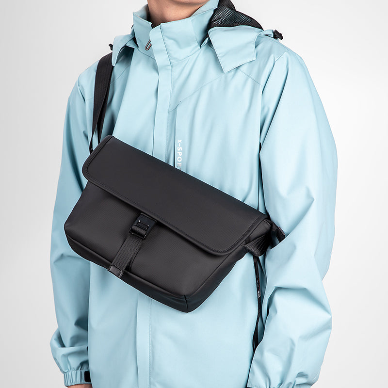 Mark Ryden black crossbody bag on model in light blue jacket - business casual travel style