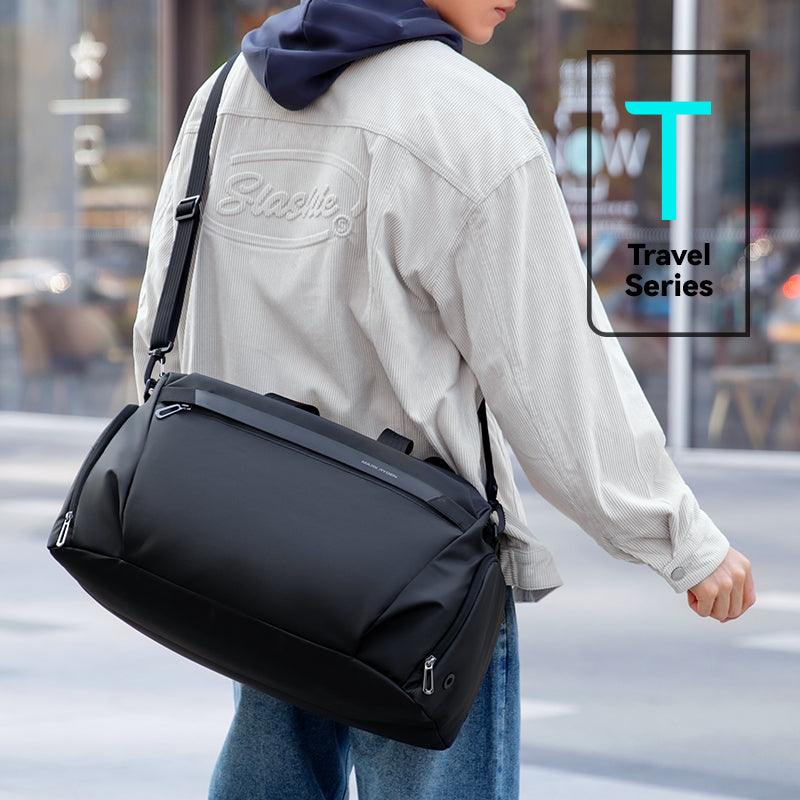 Black leather deformable fitness sports handheld crossbody multifunctional bag with adjustable strap, part of Travel Series, carried by person in casual outfit.