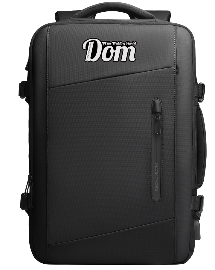 Black Mark Ryden backpack with personalized 'The Wedding Planner Dom' text, zippered front pocket, and durable design for modern travelers.