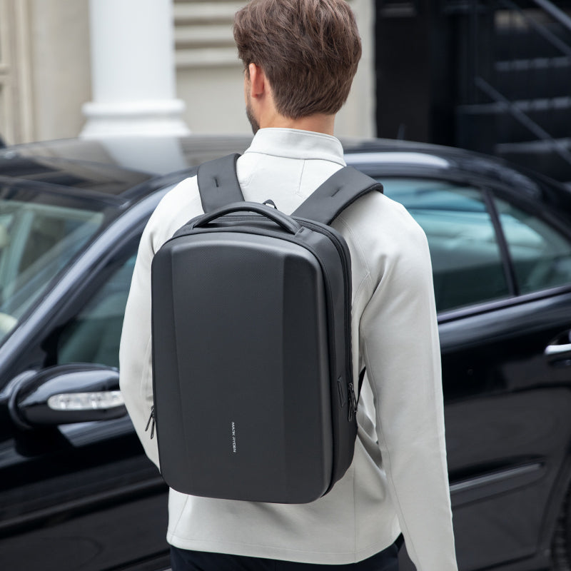 Mark Ryden Global sleek black waterproof laptop backpack man near car