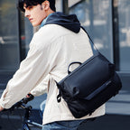 Sleek black anti-theft messenger bag on cyclist, MARK RYDEN Global