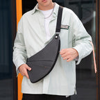 Dark gray ChestFlex chest bag with adjustable strap, worn by model in light shirt - MarkRyden Global