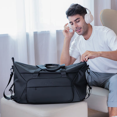 Black JourneyFlex versatile mega handbag with front pocket, dual handles, shoulder strap, and zippered main compartment, designed for modern travel.