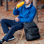 Mark Ryden black multi-functional backpack with man in blue jacket outdoors