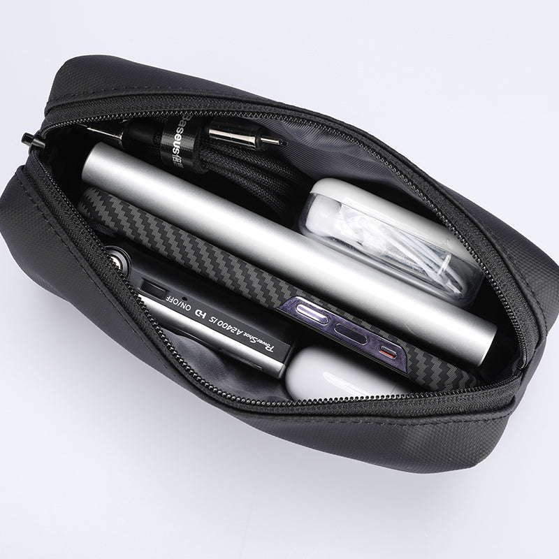 Black portable large capacity traveling toiletries bag with zippered closure, holding power bank, cables, phone, and earbuds.