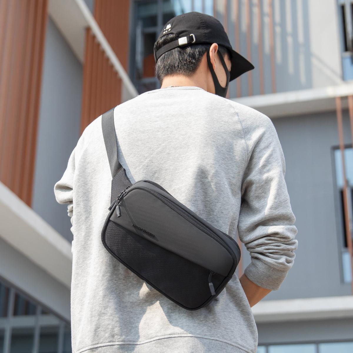 Mark Ryden Global: stylish waterproof crossbody bag with multiple compartments on man in gray sweatshirt