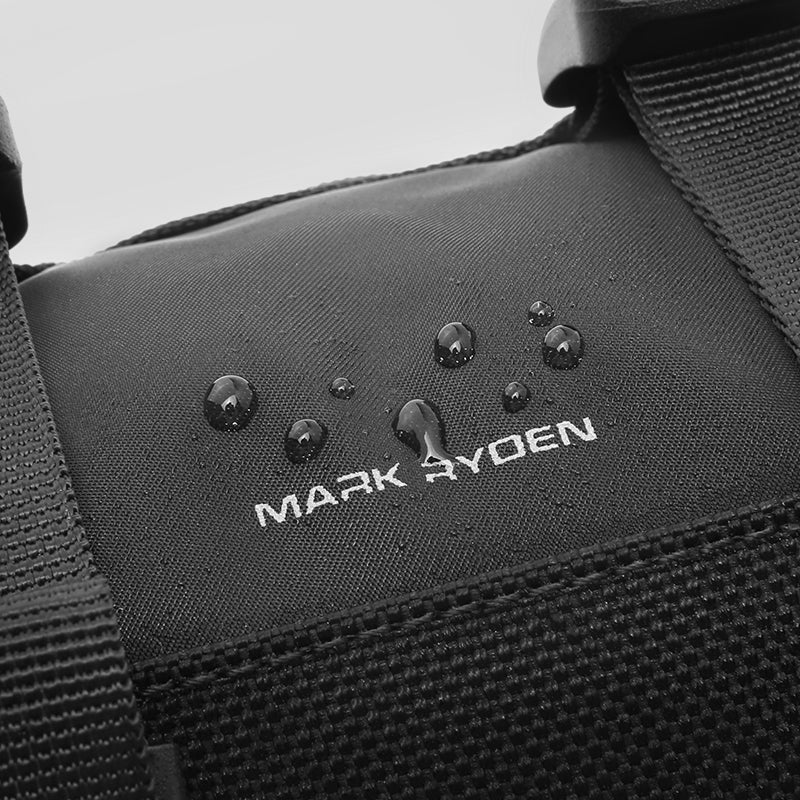 Black MotoBarrel cylinder crossbody bag with water-resistant fabric, water droplets beading, Mark Ryden logo visible