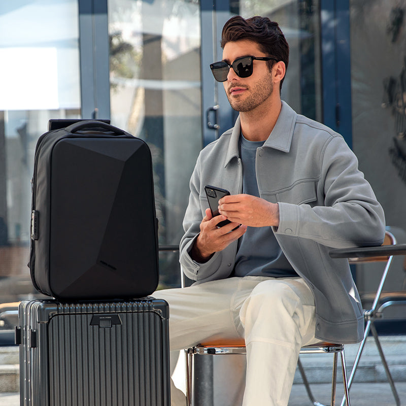 Black diamond-cut hard shell laptop backpack on luggage by MarkRyden Global