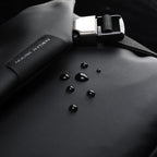 Mark Ryden black leather waterproof messenger bag with water droplets highlighting waterproof feature