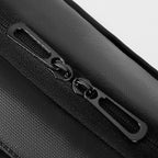 Close-up of black zippers with metal pulls on Mark Ryden Slim I seamless commuting laptop backpack, showcasing durable design and textured fabric.