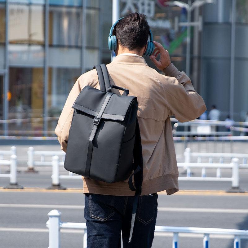Mark Ryden Global: Stylish professional black backpack on commuter with blue headphones