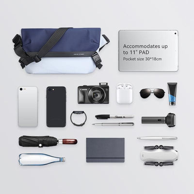 Mark Ryden navy blue and light blue messenger bag with black strap, accommodating up to 11" PAD and 30*18cm pocket, shown with phones, camera, tablet, and other items.