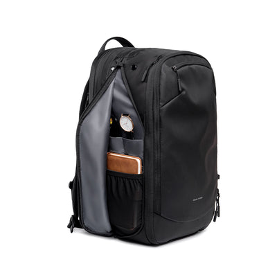Mark Ryden Globalist black expandable tech travel backpack with clamshell opening, showing interior with watch and notebook