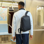 Black ZenOrganizer compact laptop backpack with minimalist design, worn by a person in a subway, perfect for daily commuting.
