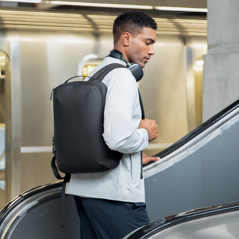 Mark Ryden Global ZenOrganizer compact black laptop backpack on escalator