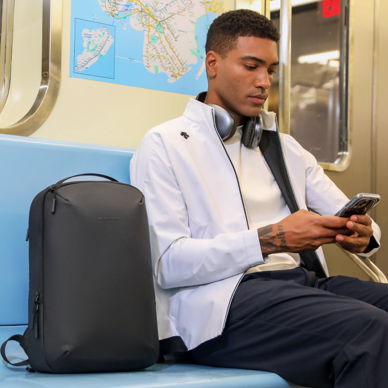 Mark Ryden Global black compact laptop backpack on subway seat for daily use