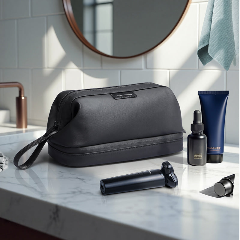 MarkRyden Global black toiletry bag with travel accessories on marble counter