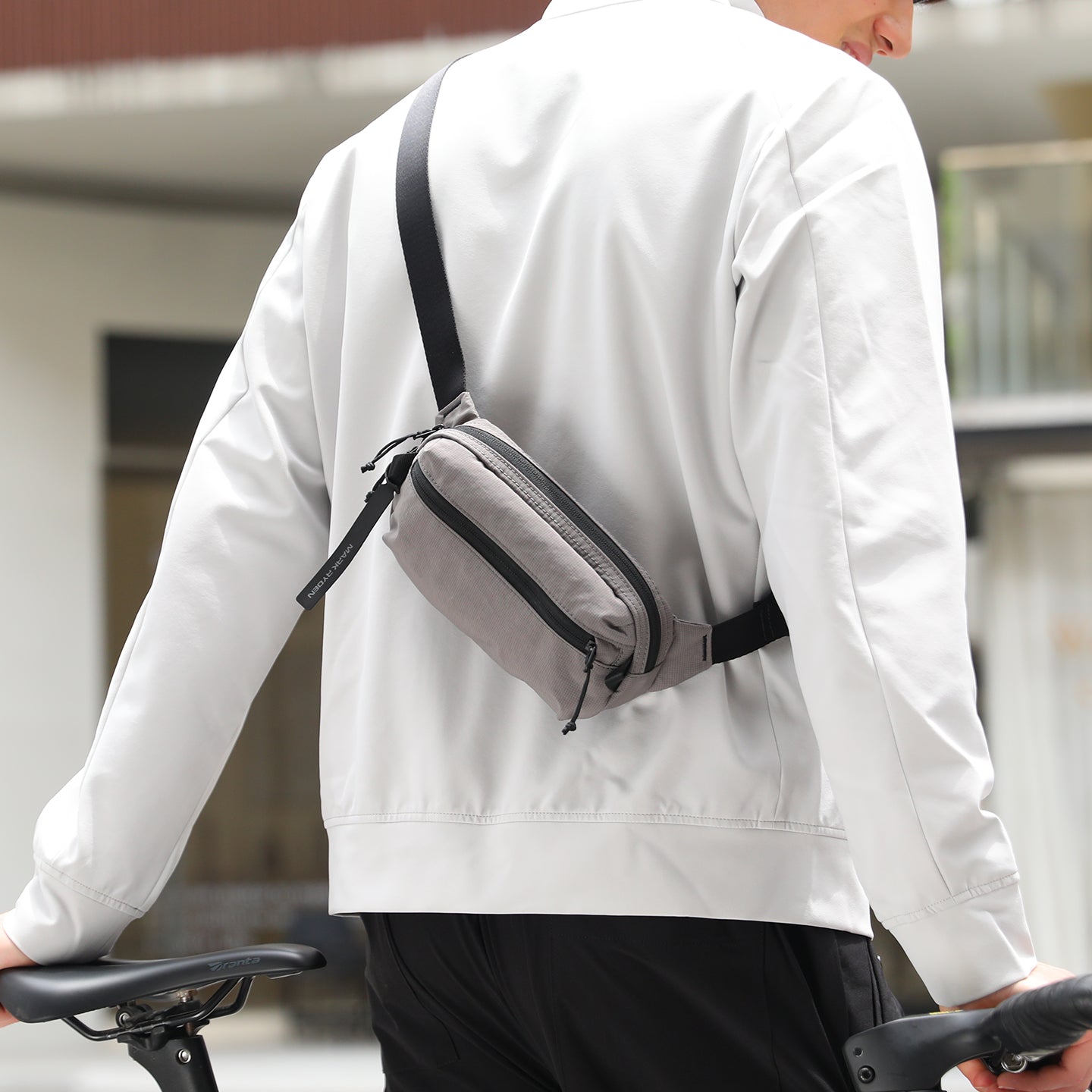 MarkRyden Global's gray anti-theft crossbody bag worn by cyclist