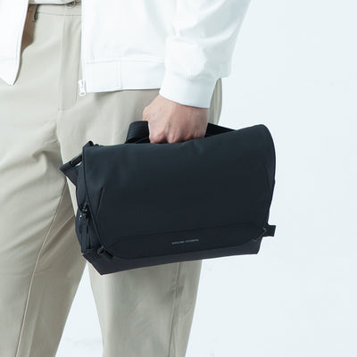 Person holding black Mark Ryden waterproof sling bag for urban gamers