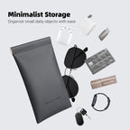 Gray Mark Ryden minimalist storage pouch with sleek design, perfect for carrying sunglasses, eyeglasses, or data cables, surrounded by small daily items like AirPods, charger, USB drive, card, smartwatch, and keys.