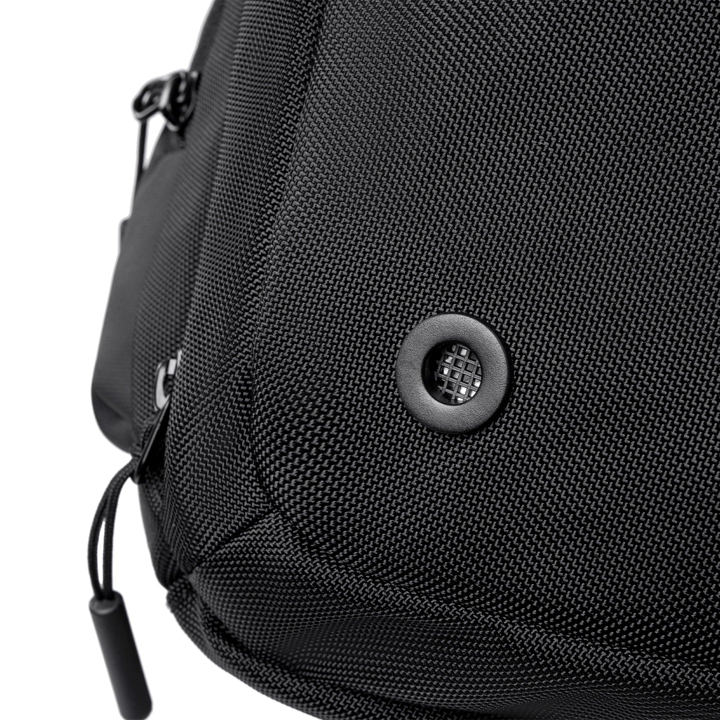 Close-up of black textured fabric on Worksman II large-capacity gym & travel duffle, featuring circular mesh vent and zipper pull.