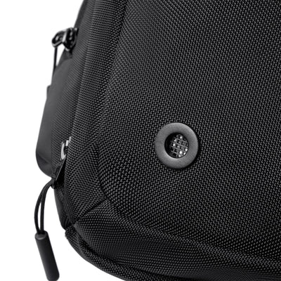 Close-up of black textured fabric on Worksman II large-capacity gym & travel duffle, featuring circular mesh vent and zipper pull.