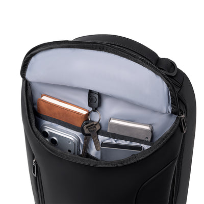 Black MarkRyden Compacto Pro backpack with futuristic design, light gray interior holding notebook, keys, smartphone, and wallet—large capacity daily backpack.