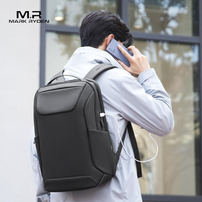 Mark Ryden black leather backpack with USB port on model using phone