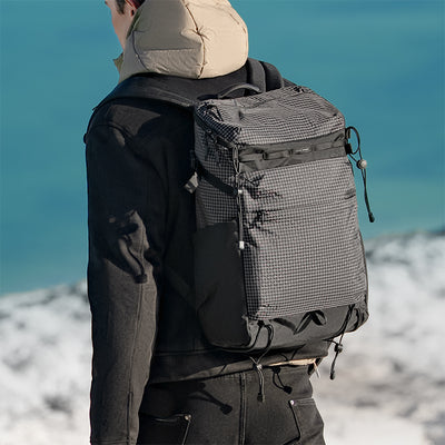 Back view of gray checkered AeroPro 17.3-inch laptop backpack with black accents, multiple compartments, designed for travelers with enhanced support.