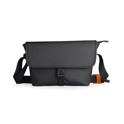 Black business casual travel crossbody bag with flap closure, adjustable straps, and orange accent detail.